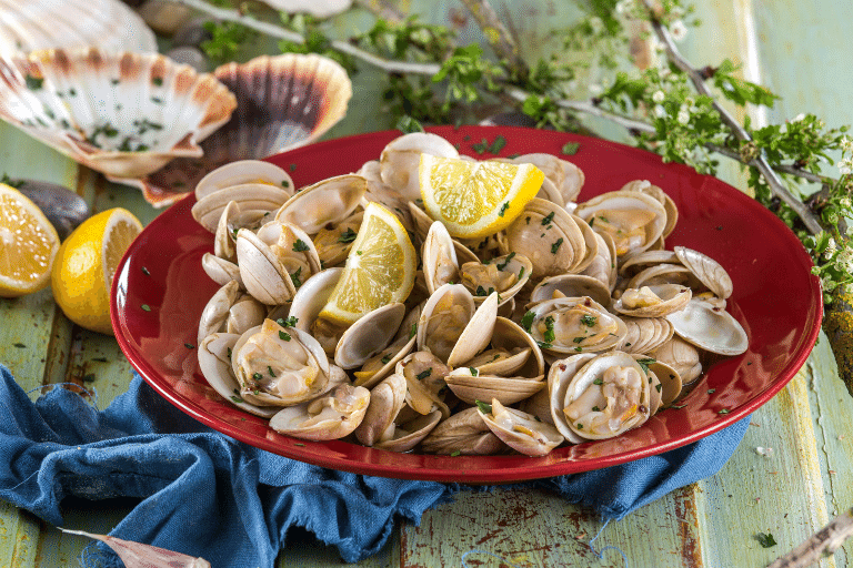 Amêijoas à Bulhão Pato Clássicas, servidas numa taça com caldo aromático e decoradas com coentros e limão