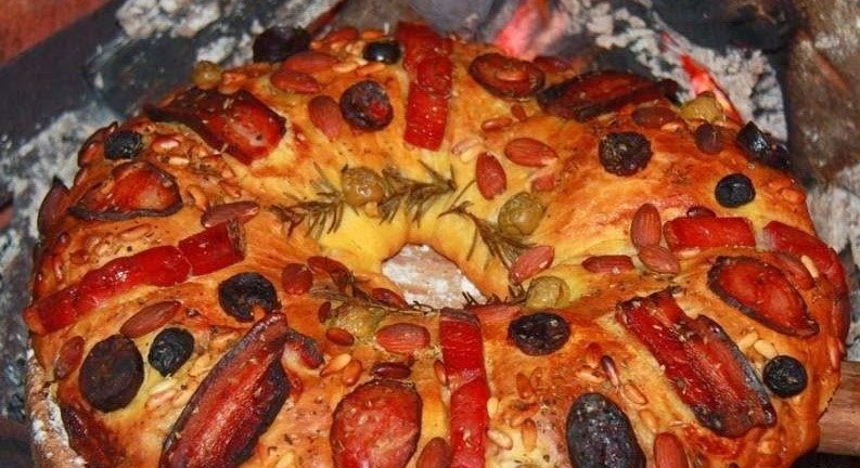 Bolo Rei de Enchidos, pão salgado recheado em forma de coroa, dourado e polvilhado com sésamo