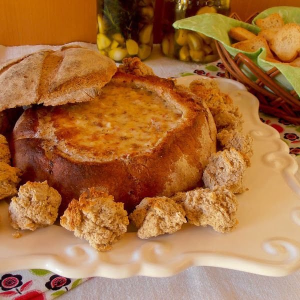 Broas Recheadas de Natal caseiras, douradas e polvilhadas com açúcar, dispostas numa bandeja decorativa