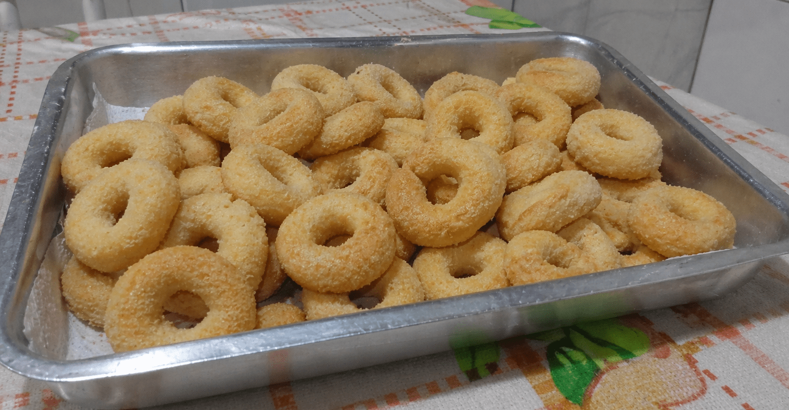 Rosquinhas de leite condensado douradas e polvilhadas com açúcar em um prato