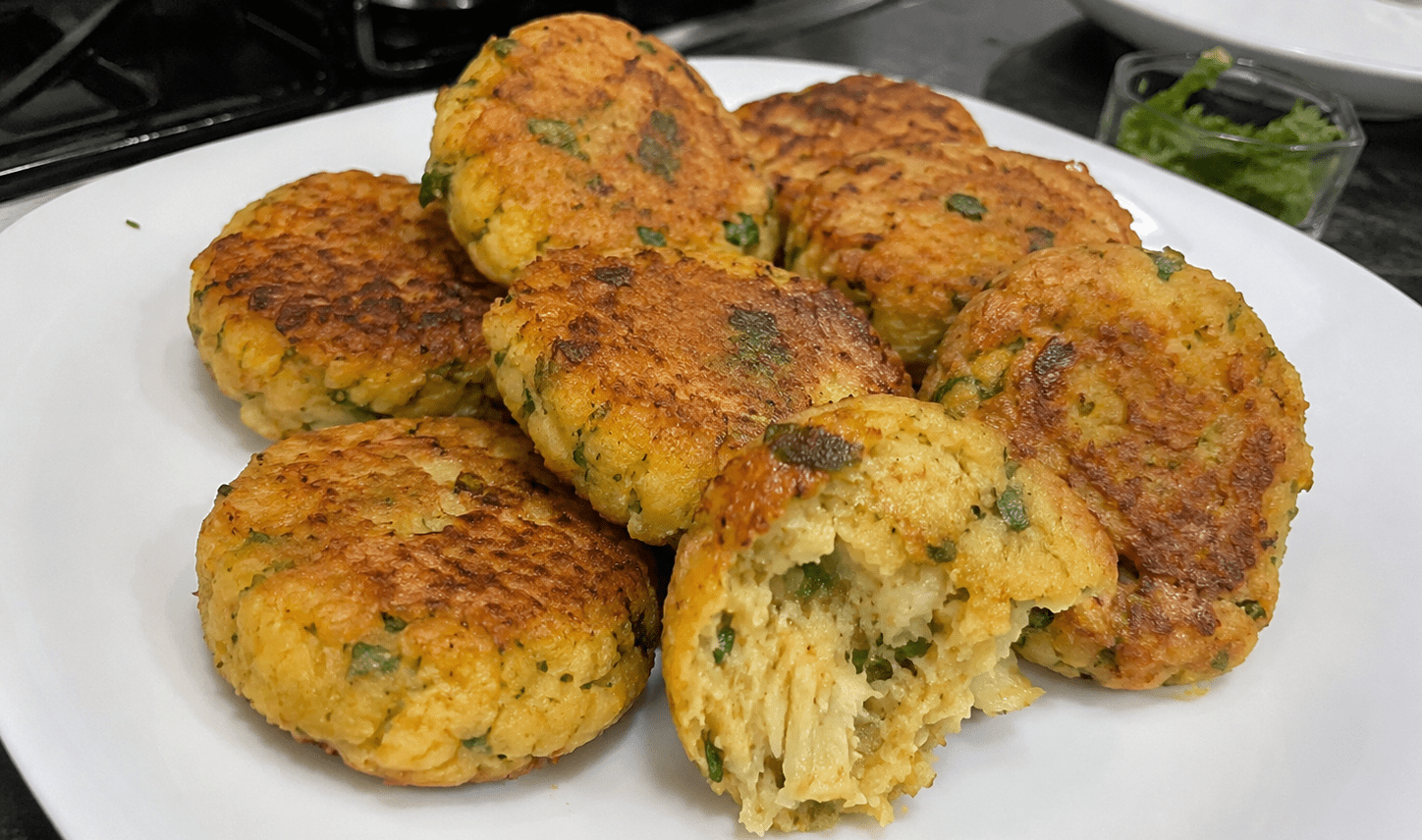 Bolinhos de bacalhau com grão-de-bico dourados e servidos com fatias de limão