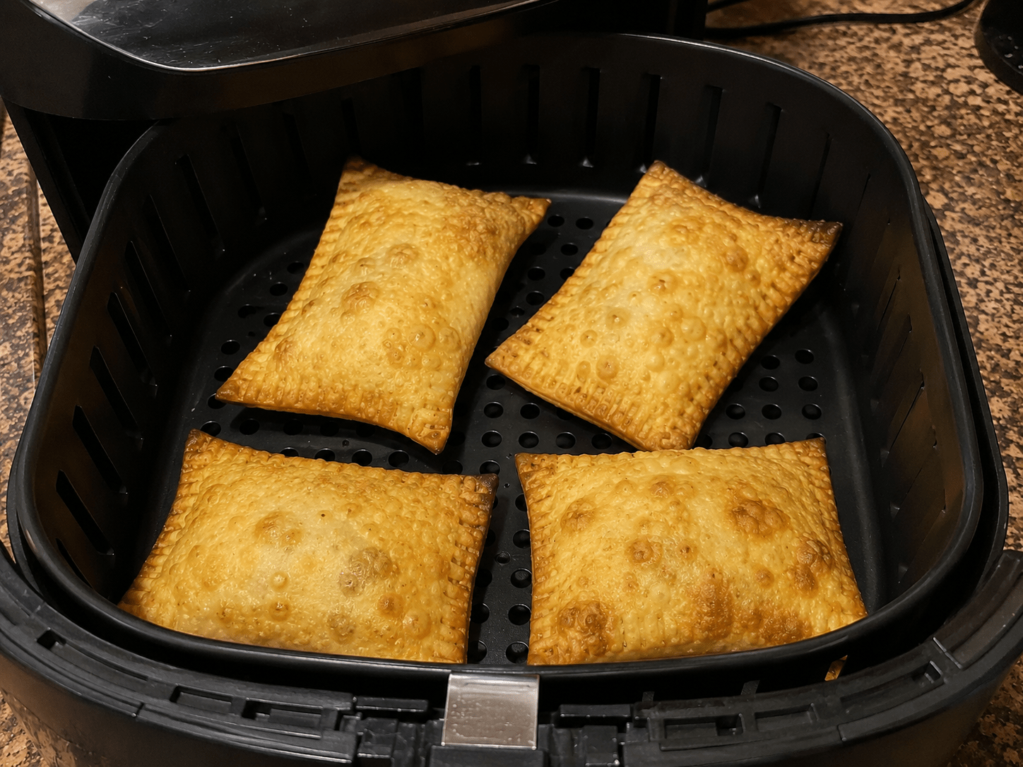 Pastéis de feira dourados e crocantes preparados na air fryer dispostos em uma travessa