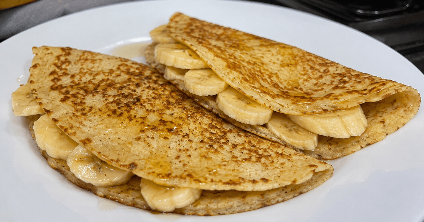 Pilha de panquecas de banana douradas decoradas com rodelas de fruta e mel