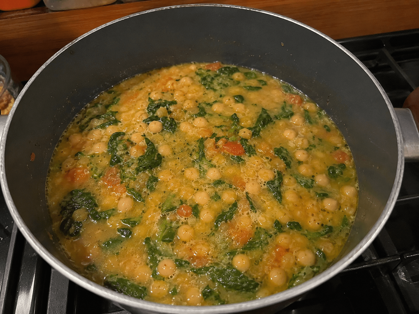 Tigela com sopa cremosa de grão-de-bico e folhas frescas de espinafre servida quente