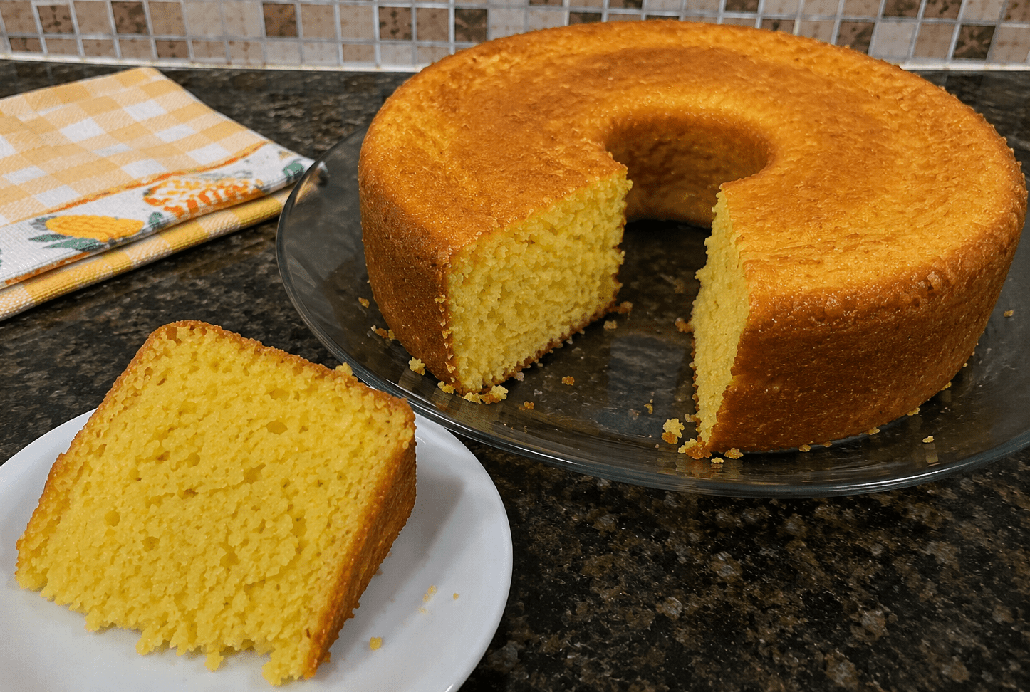 Bolo de milho caseiro dourado e fofinho servido em um prato sobre a mesa de café