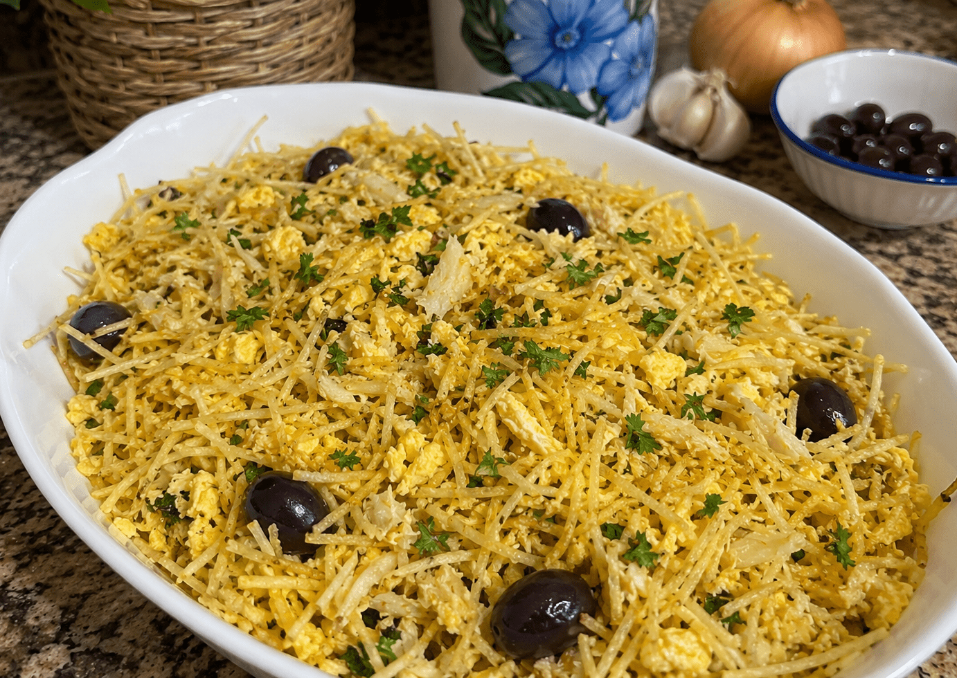 Prato tradicional de Bacalhau à Brás cremoso guarnecido com salsa fresca e azeitonas pretas